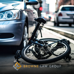 A bike knocked down in the road under the front bumper of a silver car in Casa Grande, AZ