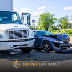 A blue car and a white truck with front end damage in the road after a truck accident in Goodyear